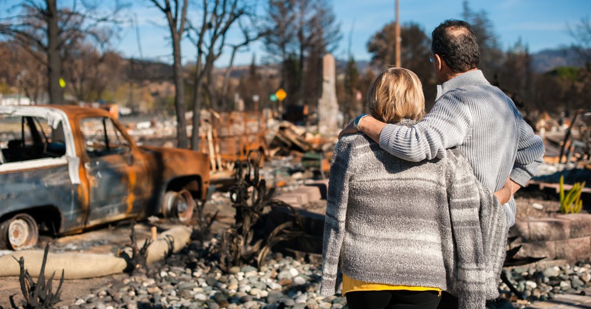 Couple checking ruins after fire disaster.