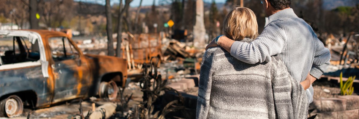 Couple checking ruins after fire disaster.