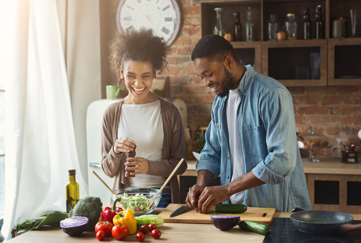 A happy young couple cooking at home.