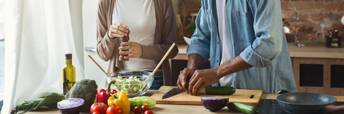 A happy young couple cooking at home.