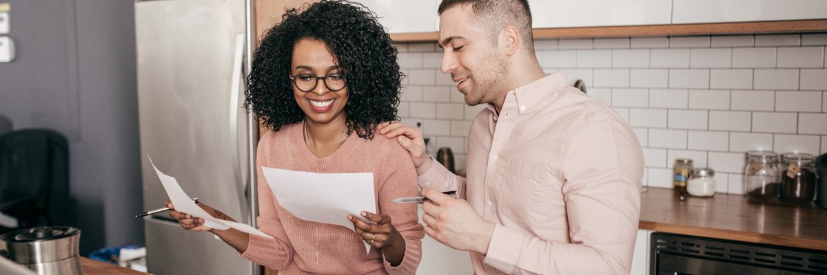 Couple looking over paperwork together in the kitchen.