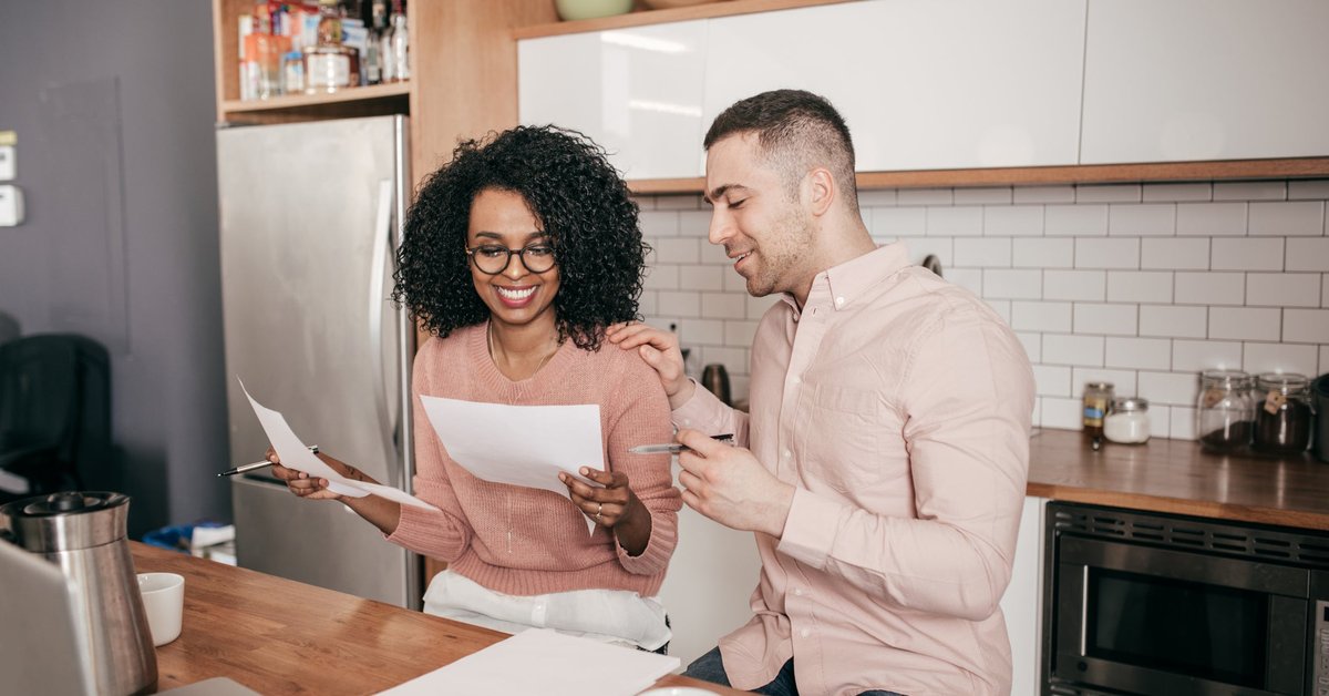 Couple looking over paperwork together in the kitchen.