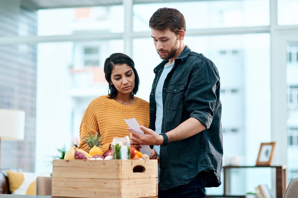 Couple looking unhappy with receipt for their fresh produce.