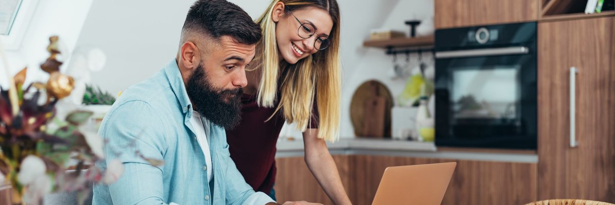 Couple looking up something together on laptop.
