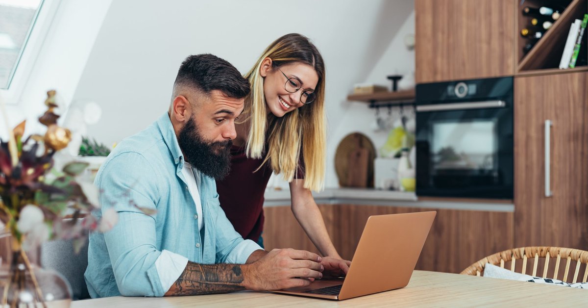 Couple looking up something together on laptop.
