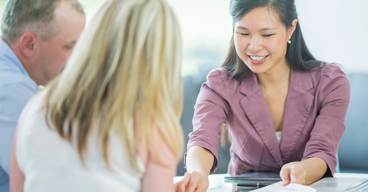 A couple look over loan documents with their loan officer.