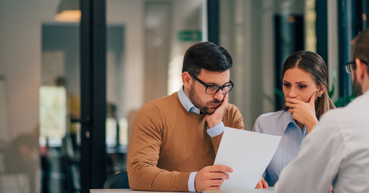 Couple seemingly not happy about information provided to them by professional in office.