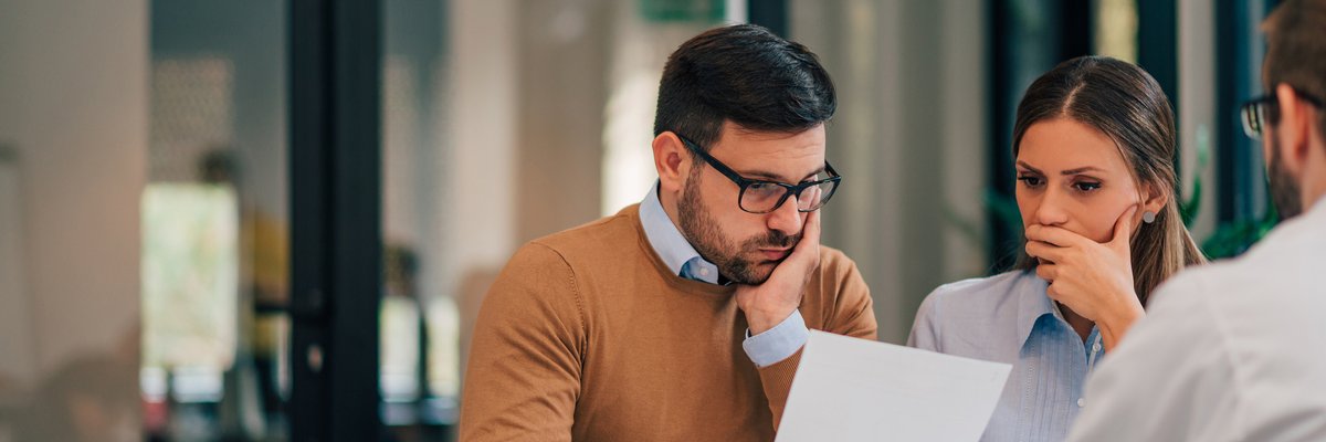 Couple seemingly not happy about information provided to them by professional in office.