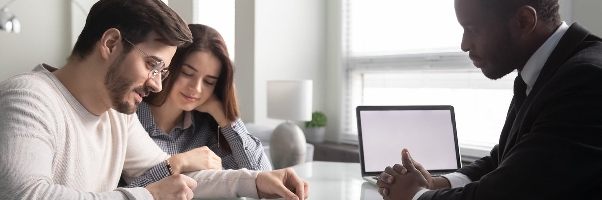 Couple signing paperwork with an agent.