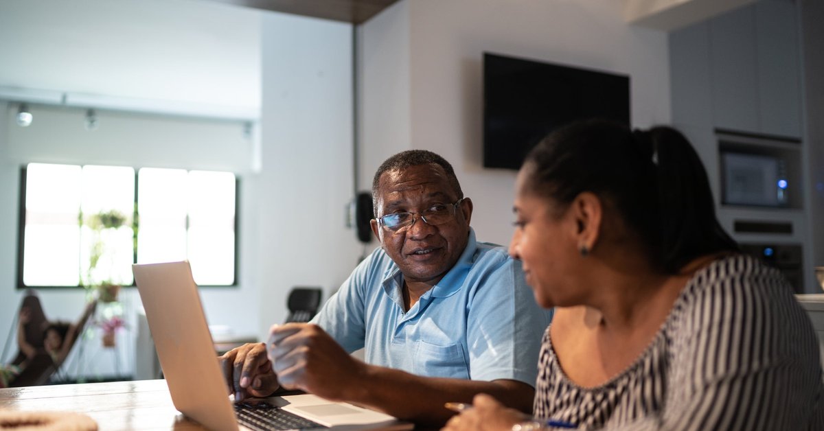 A couple sit at home and look over their personal finances.