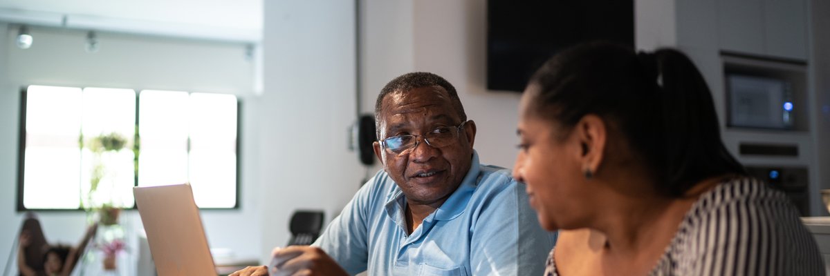 A couple sit at home and look over their personal finances.