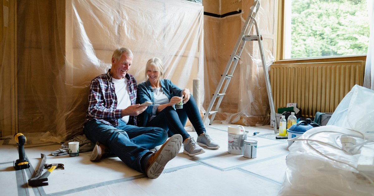 Couple sitting relaxing in a room that's undergoing renovation.