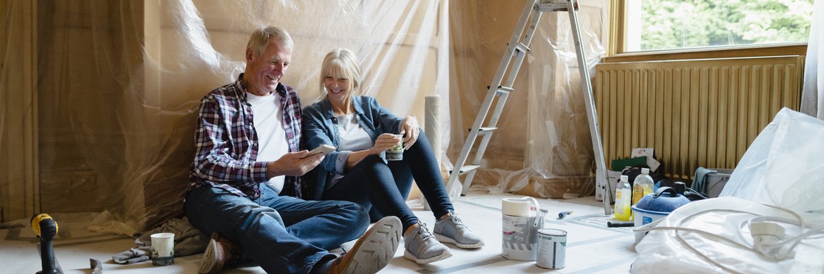Couple sitting relaxing in a room that's undergoing renovation.