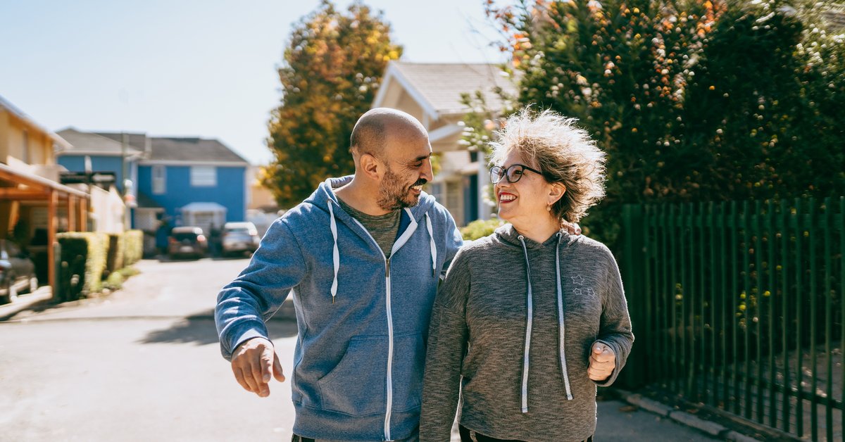 Couple walking in neighborhood of gated community.