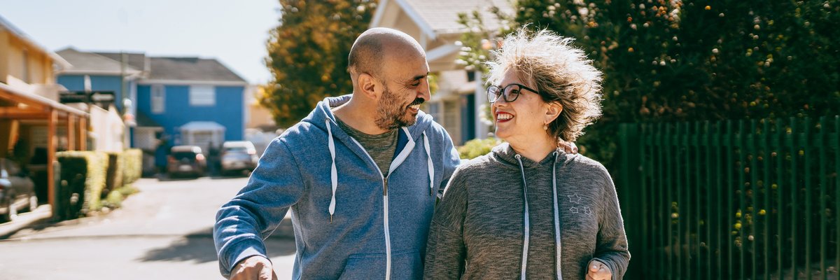 Couple walking in neighborhood of gated community.