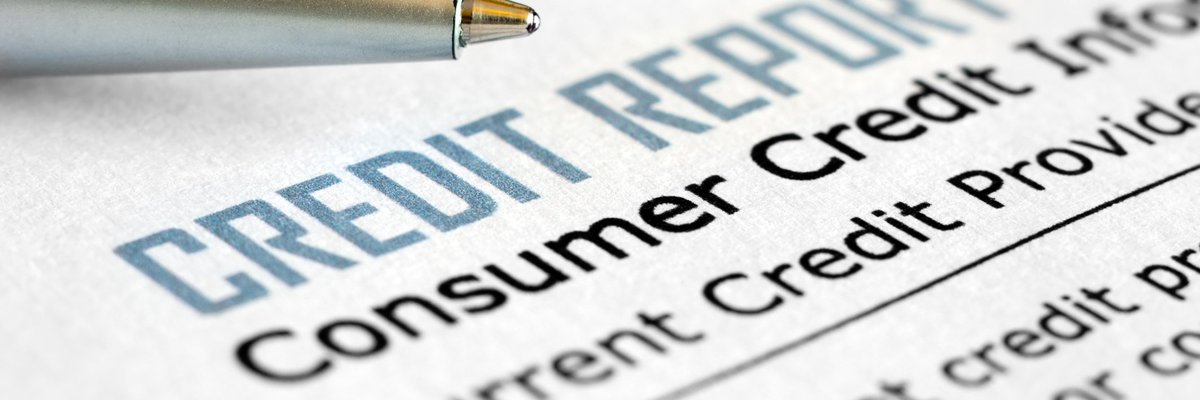 A pen next to a piece of paper that says credit report.