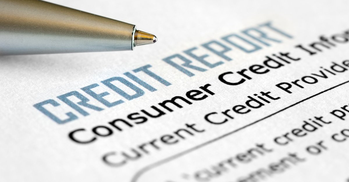 A pen next to a piece of paper that says credit report.
