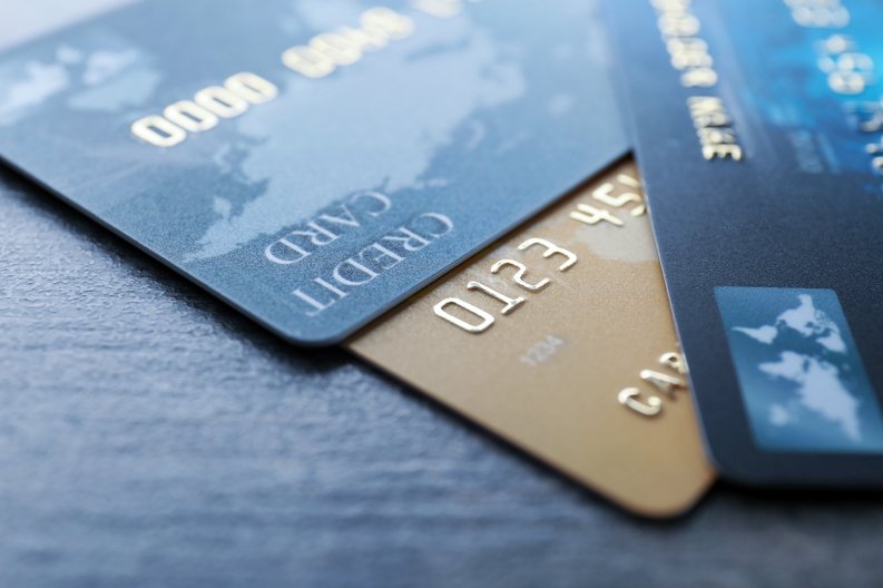 Three credit cards on top of each other on a table.
