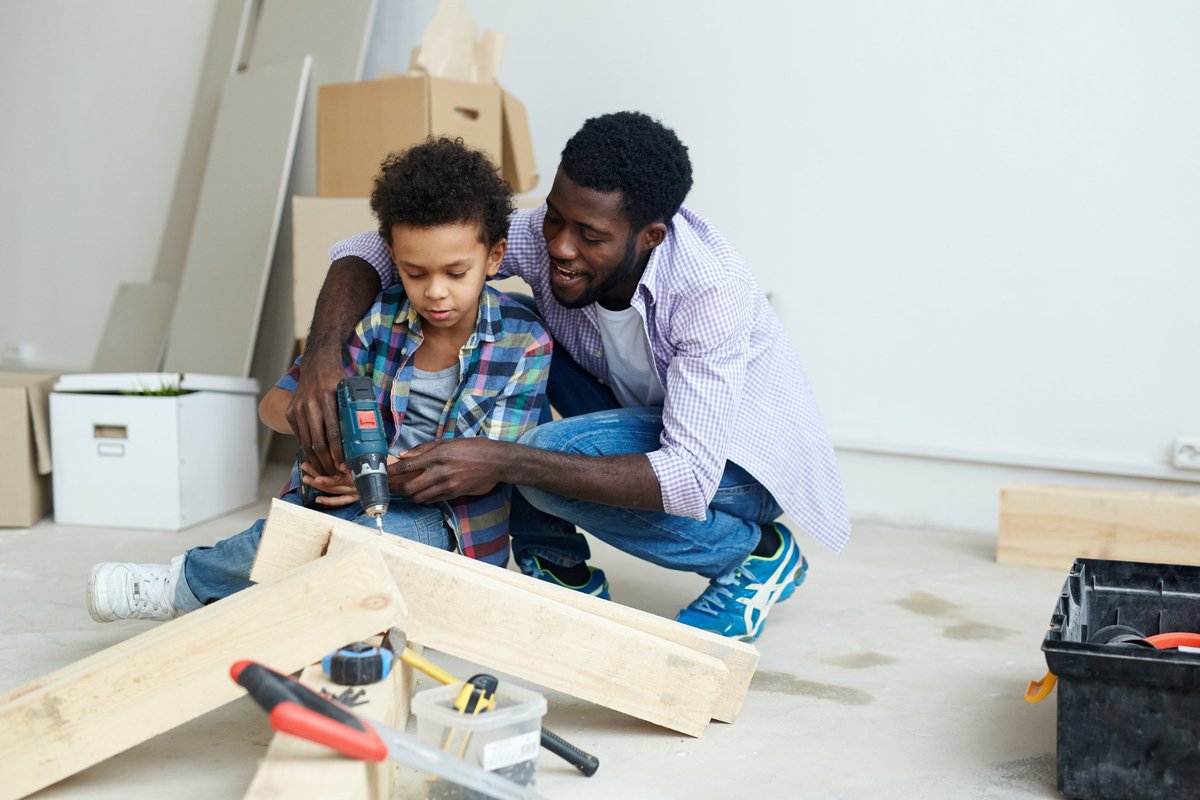 A father and child working on home improvements together.
