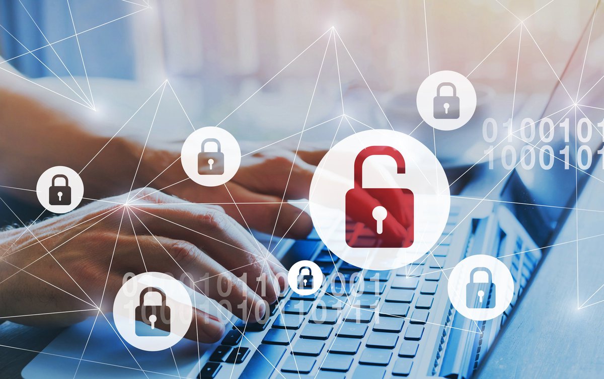 Data breach: web of locked padlocks and one unlocked padlock superimposed over person typing on a keyboard.