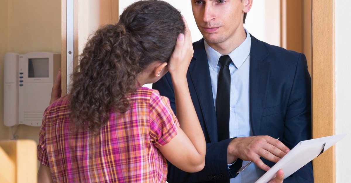 Man in suit standing in doorway glaring at woman.