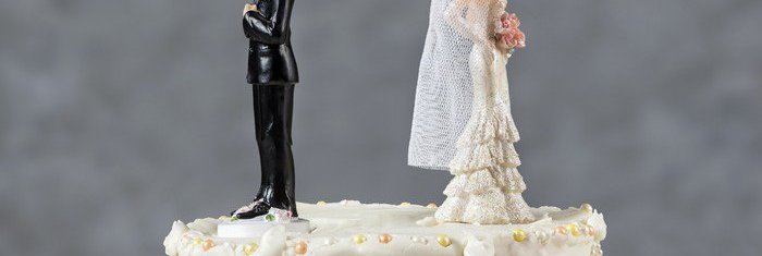 wedding cake with bride and groom facing away from each other