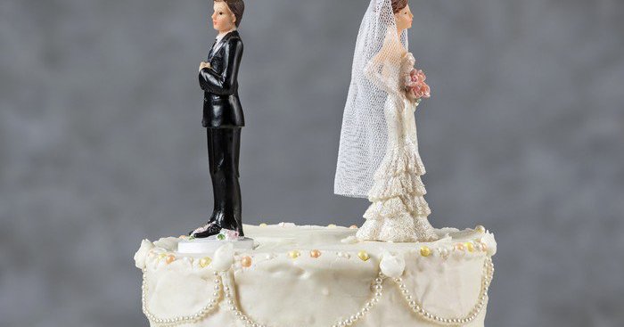 wedding cake with bride and groom facing away from each other