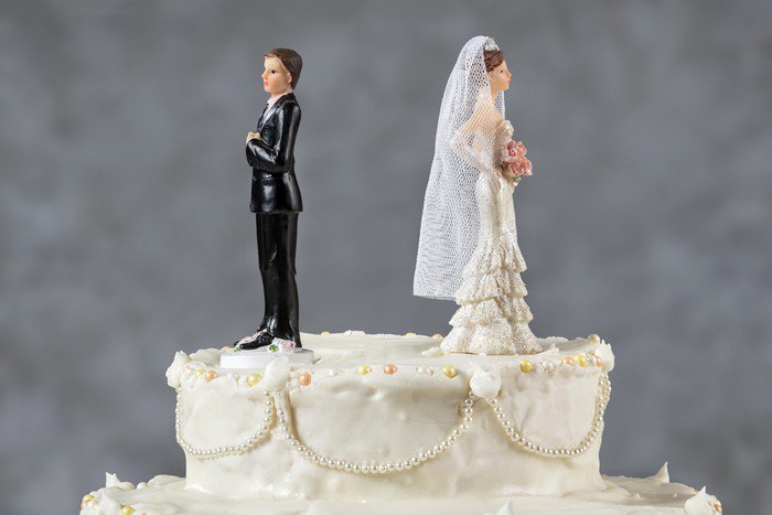 wedding cake with bride and groom facing away from each other