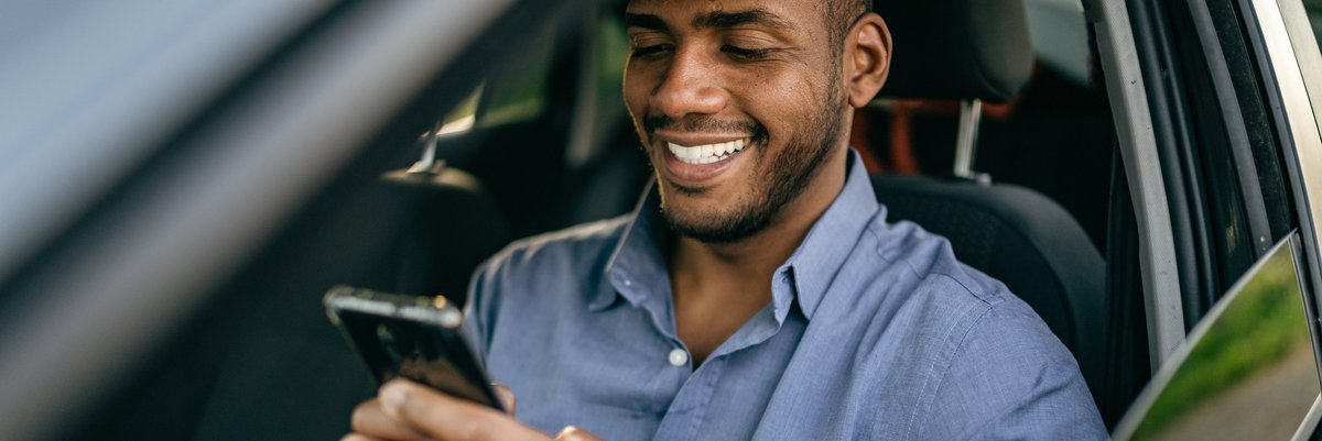 Driver sitting in driver's seat of vehicle and using cellphone.
