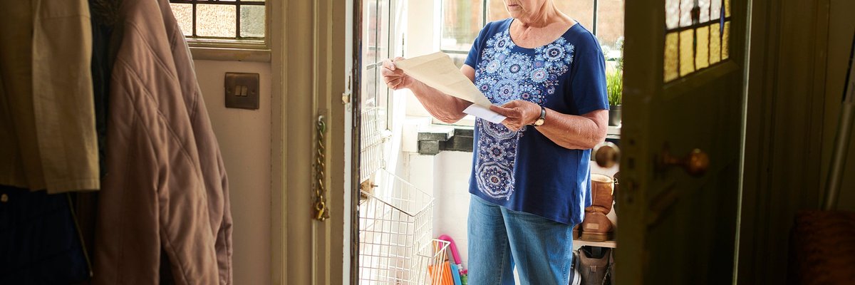 Elderly woman appears concerned about letter she's reading