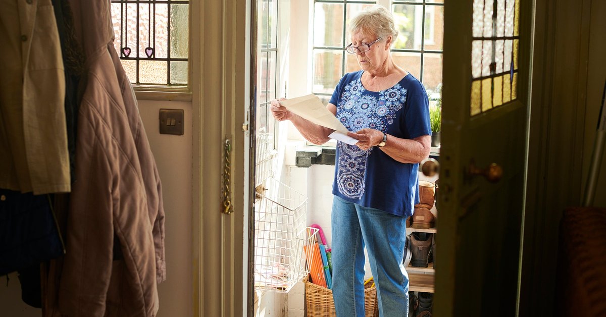 Elderly woman appears concerned about letter she's reading