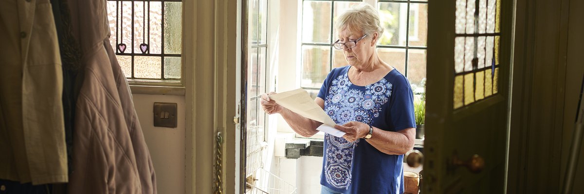 Elderly woman appears concerned about letter she's reading