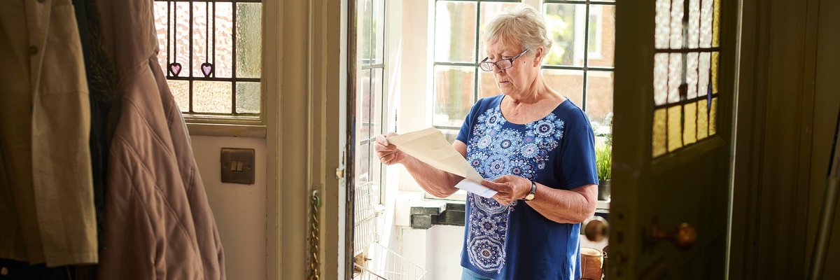 Elderly woman appears concerned about letter she's reading