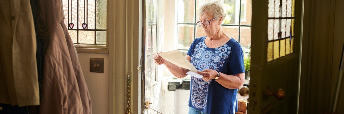 Elderly woman appears concerned about letter she's reading