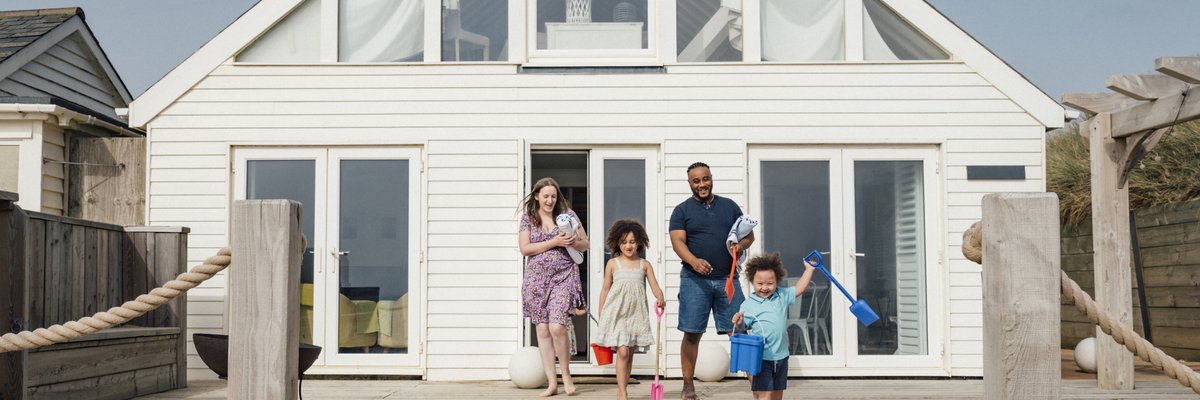 Family emerging from a beach house.