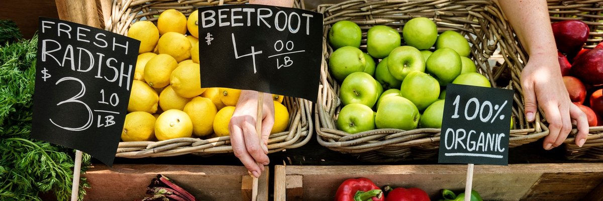 Person putting price signs on vegetables at the farmers market