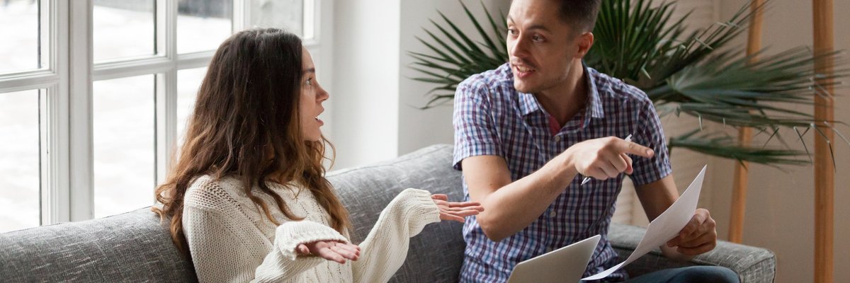Frustrated Man Pointing At Bill While His Girlfriend Shrugs Her Shoulders