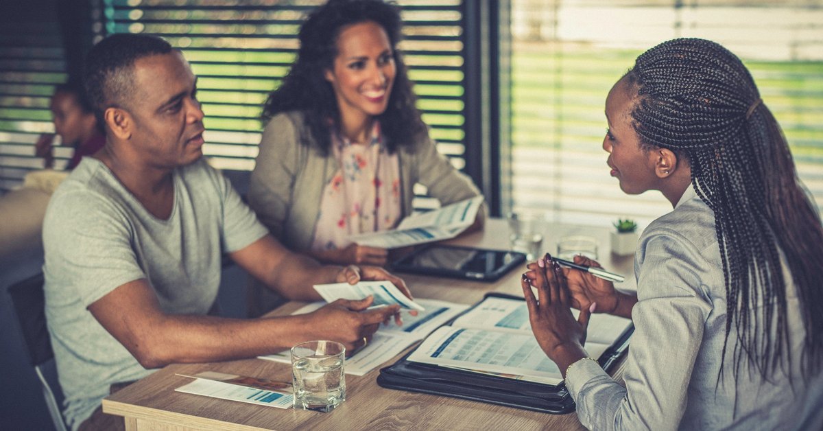 Financial professional talks to couple over paperwork