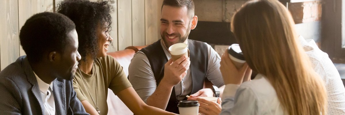Smiling friends having coffee in a cafe.