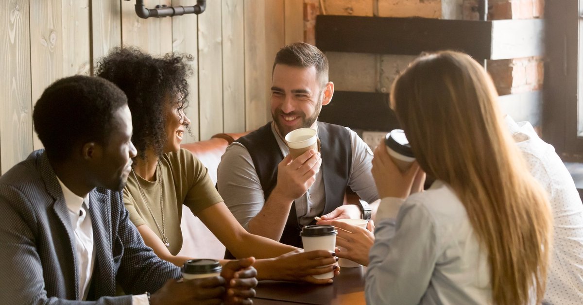 Smiling friends having coffee in a cafe.