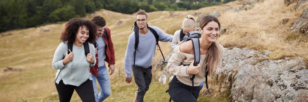 A group of friends hiking up a hillside.