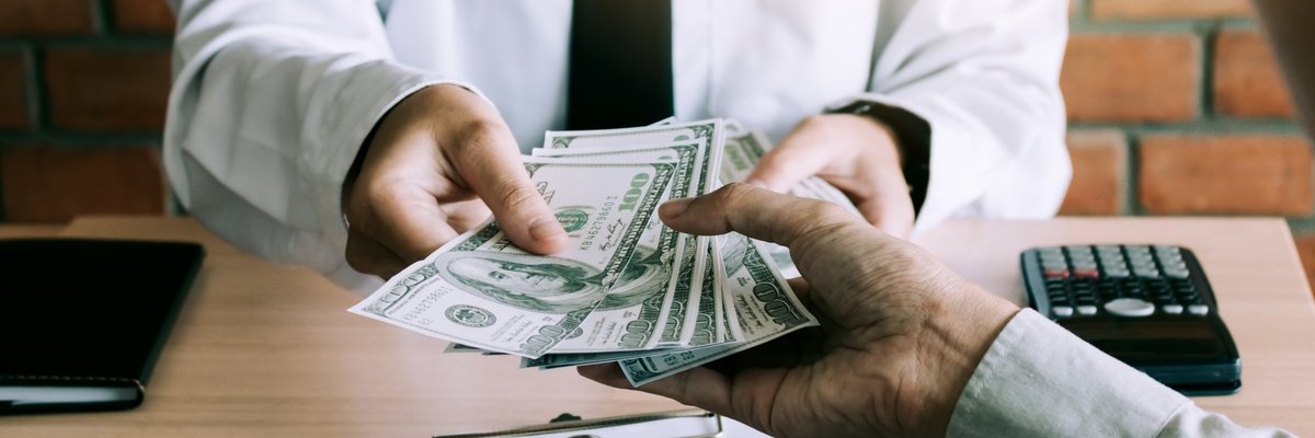 Man Handing Over $100 Bills