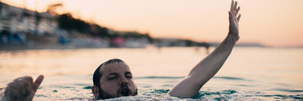 Bearded guy flailing around in the ocean.