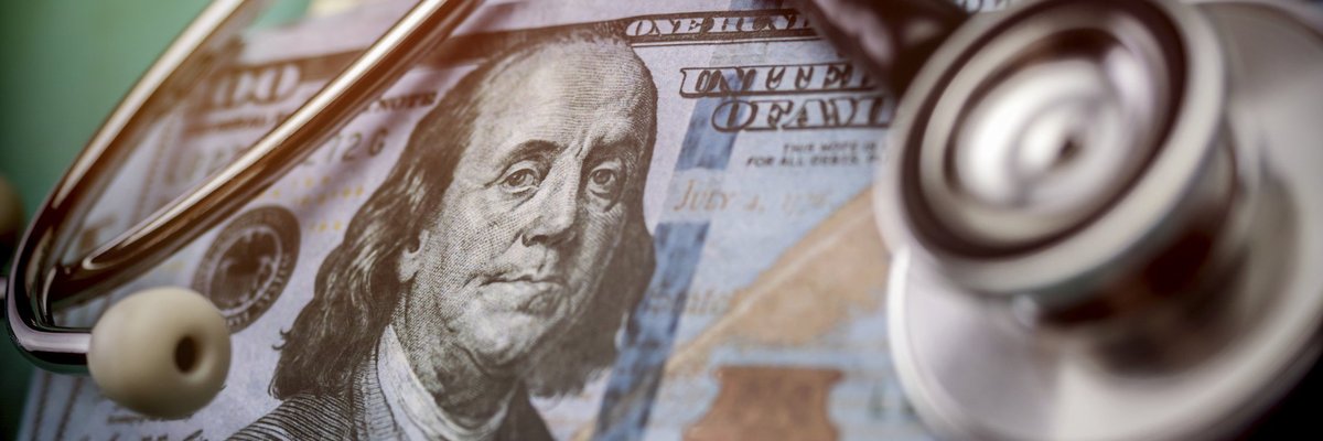 A stethoscope listening in to what's happening inside a stack of 100 dollar bills.