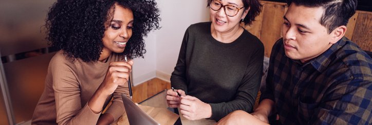 A couple meets with a financial advisor in an office.