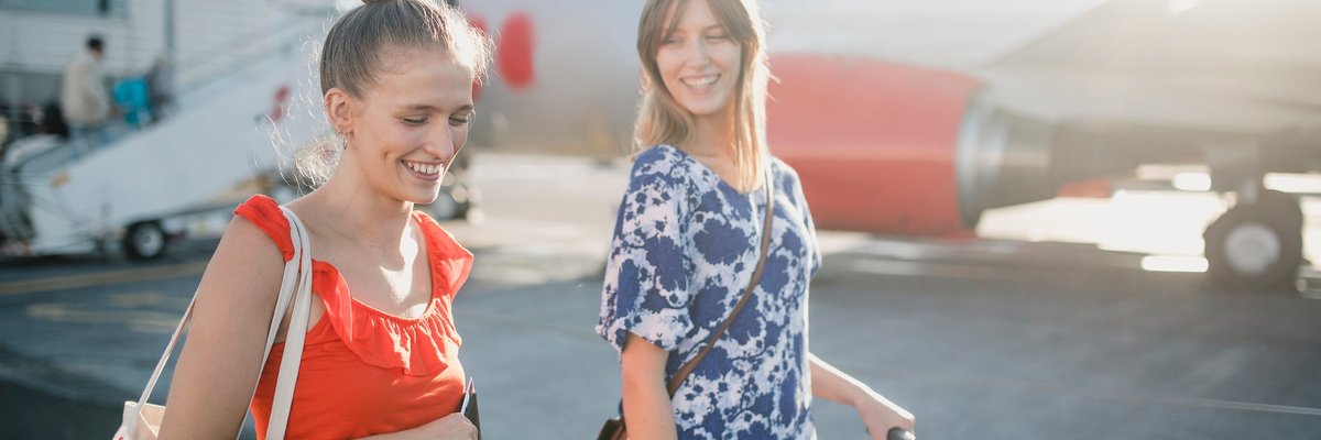 A couple walks to their flight in the sunshine.