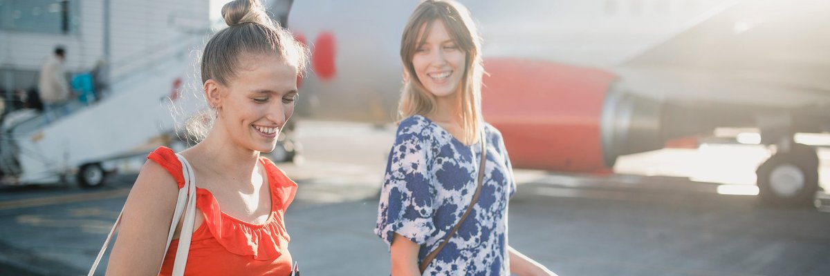 A couple walks to their flight in the sunshine.