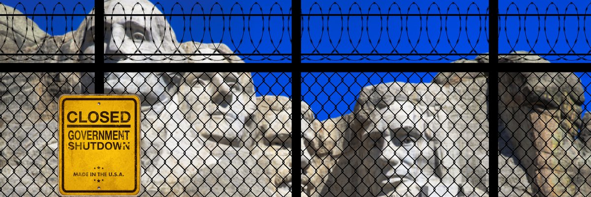 Mt. Rushmore in the background with a barbed-wire fence and "Closed -- Government Shutdown" notice in the foreground.