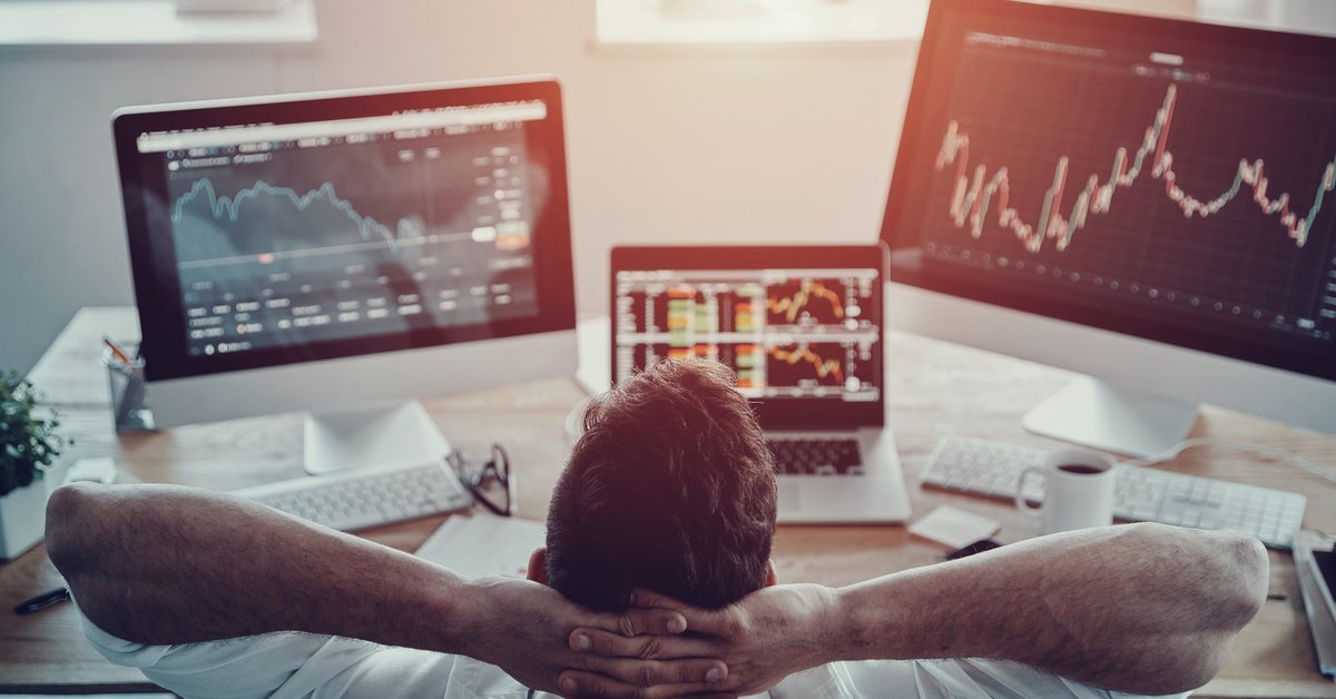 Guy leaning back and monitoring three screens featuring various stock information.