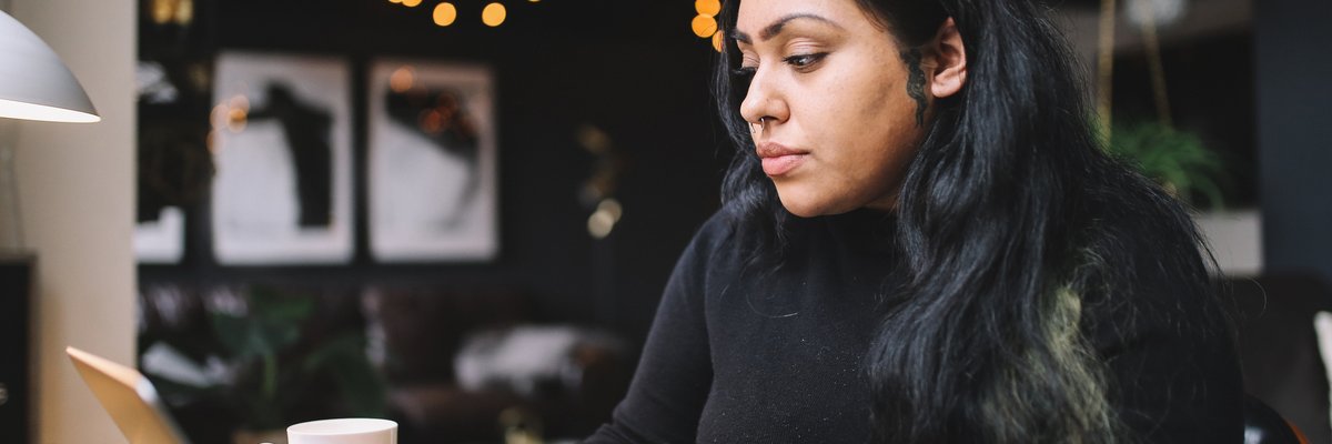 A person uses a laptop at a desk at home.